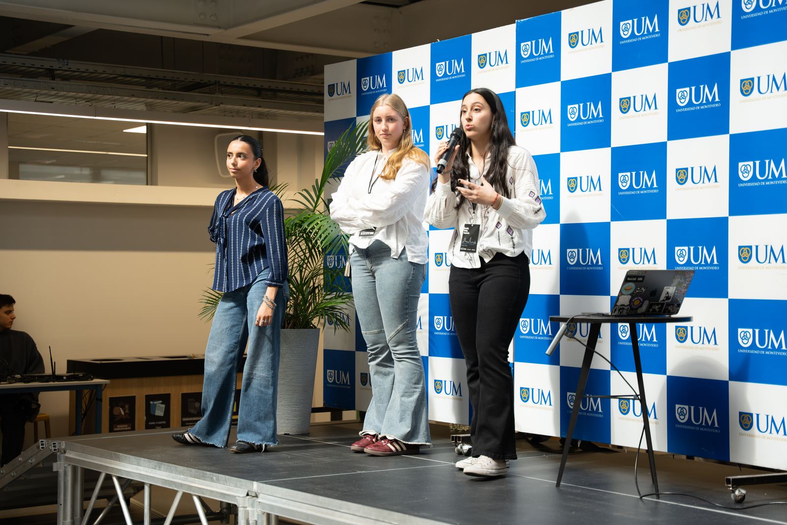 Tres integrantes de un equipo presentan en el escenario