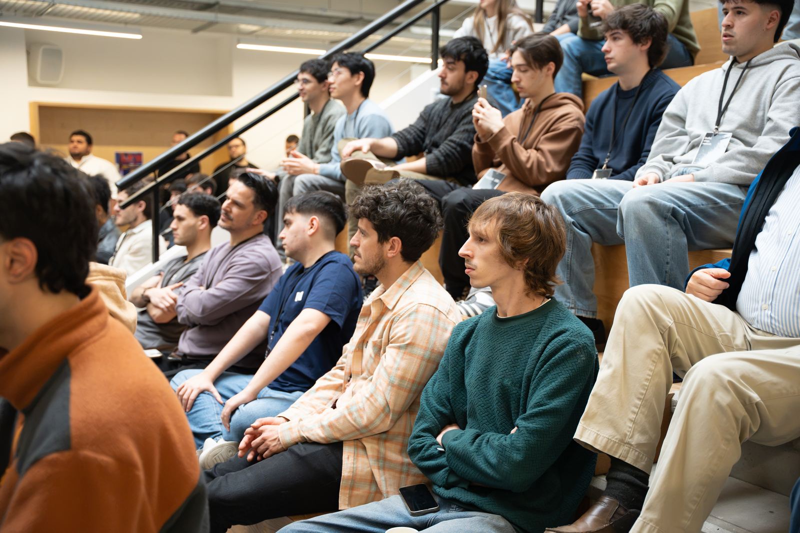 Participantes sentados en las gradas escuchando